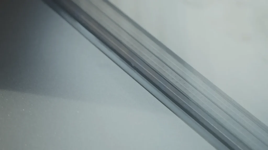 Close-up of the edge and seal of the glass structure, where the glass meets the aluminum profile.