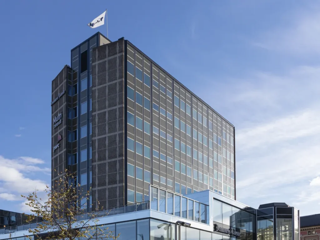Glass and concrete office building with blue sky above.
