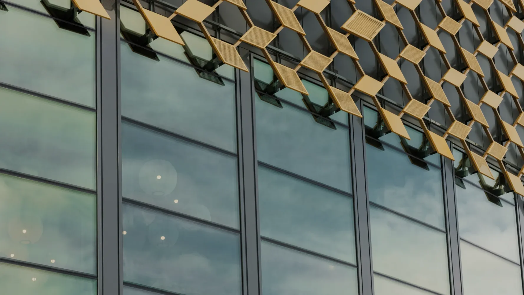Curved glass facade on a building with gold-colored facade elements.