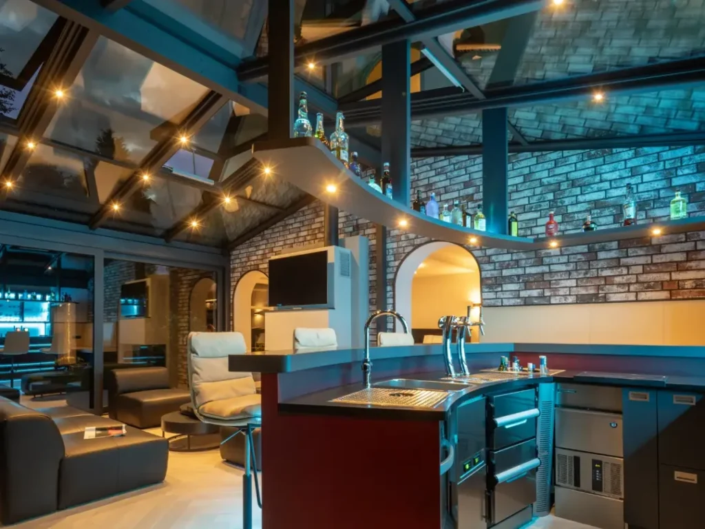 Modern bar and lounge interior with glass walls, brick walls and bottles arranged on shelves under a ceiling with spotlights.